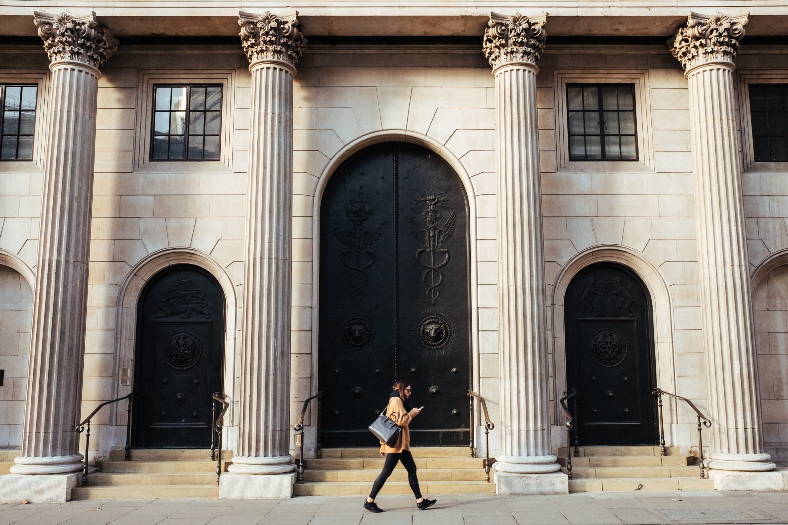 Woman walking in front of grand building